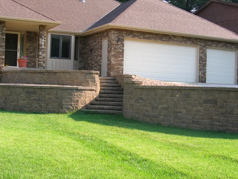 Front view of a modern brick house with a landscaped yard and stone steps leading to the entrance.